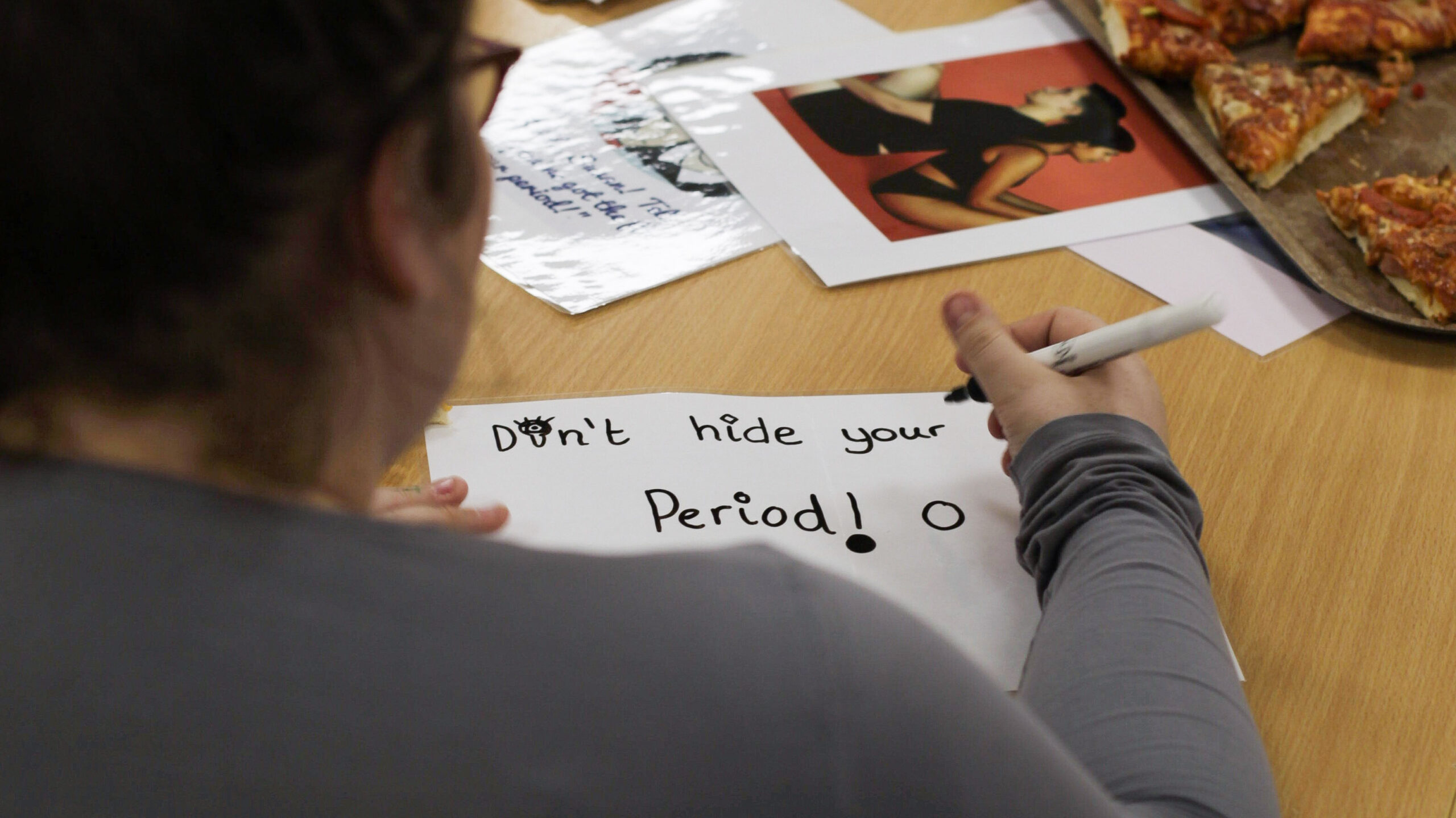 girl writing "Don't hide your period"
